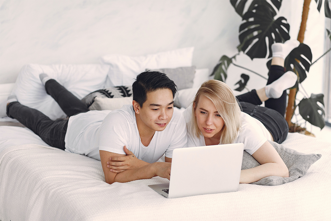 Couple watching a laptop in bed