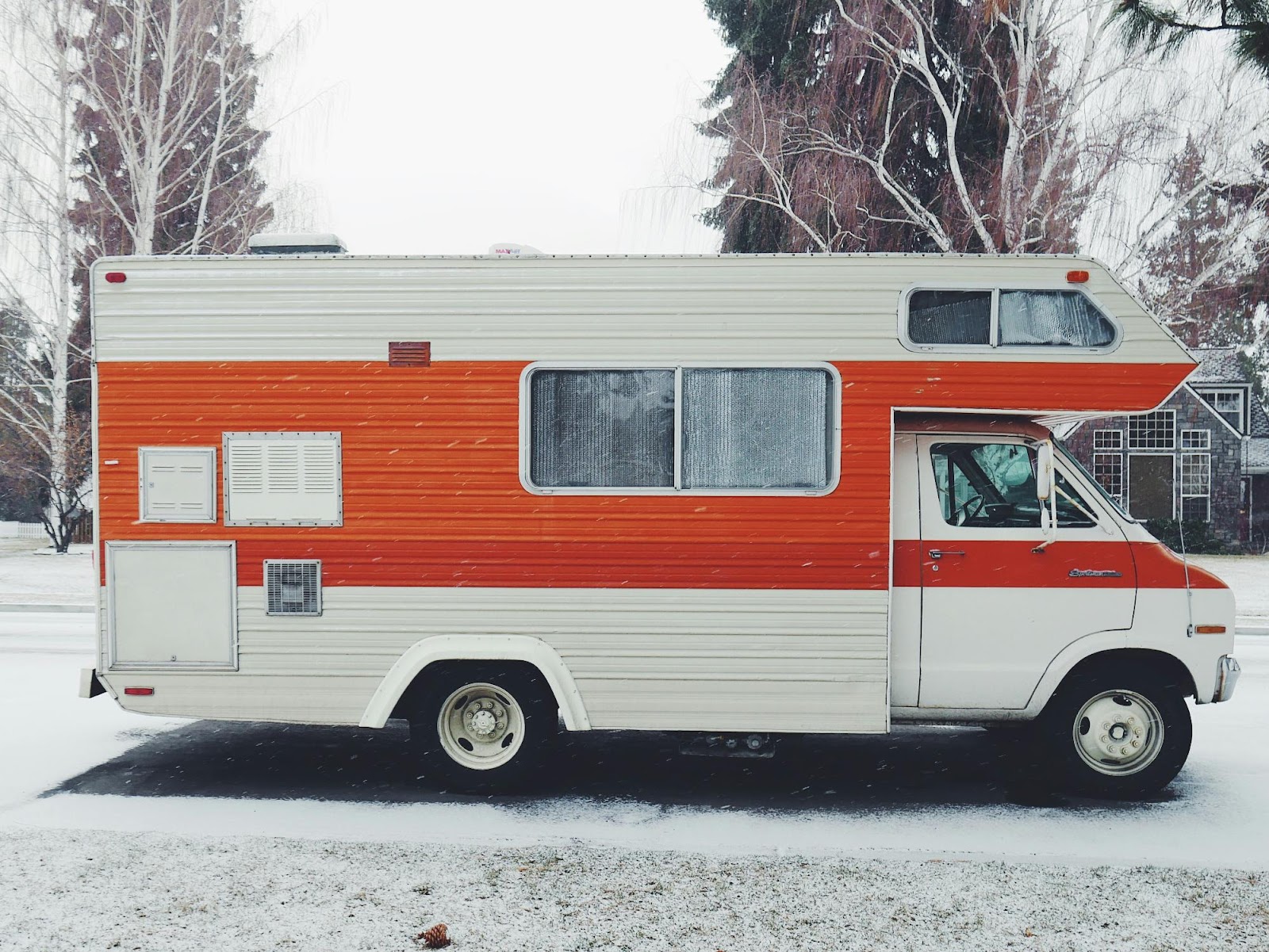 a red and white bus parked in the snow