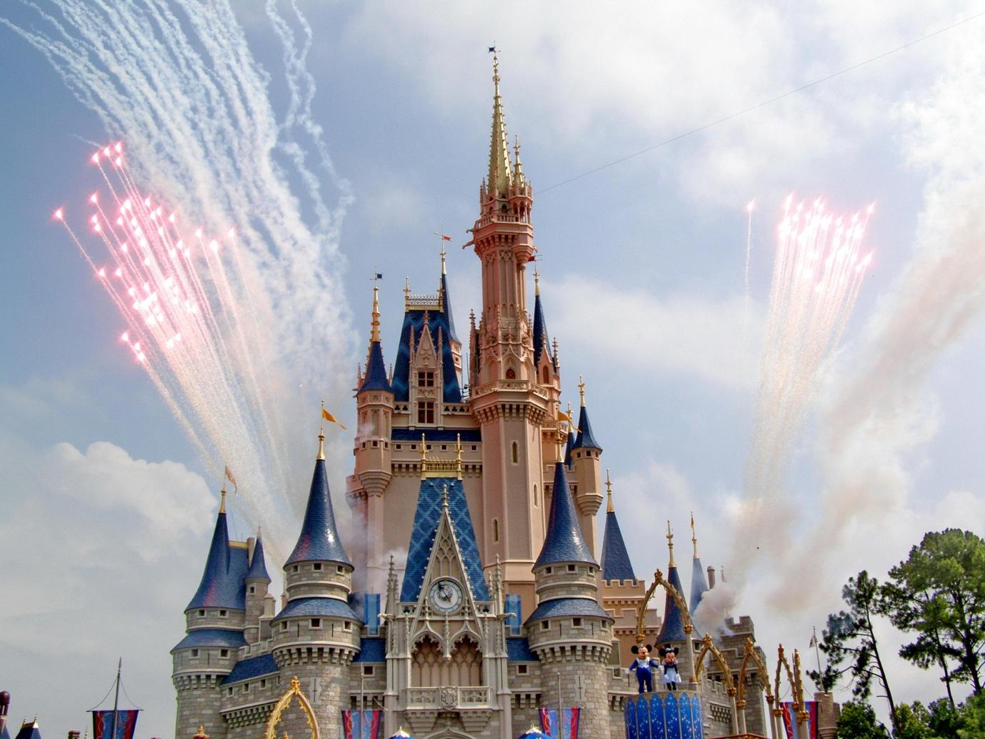 castle with colorful ornamental details located in amusement park during fireworks