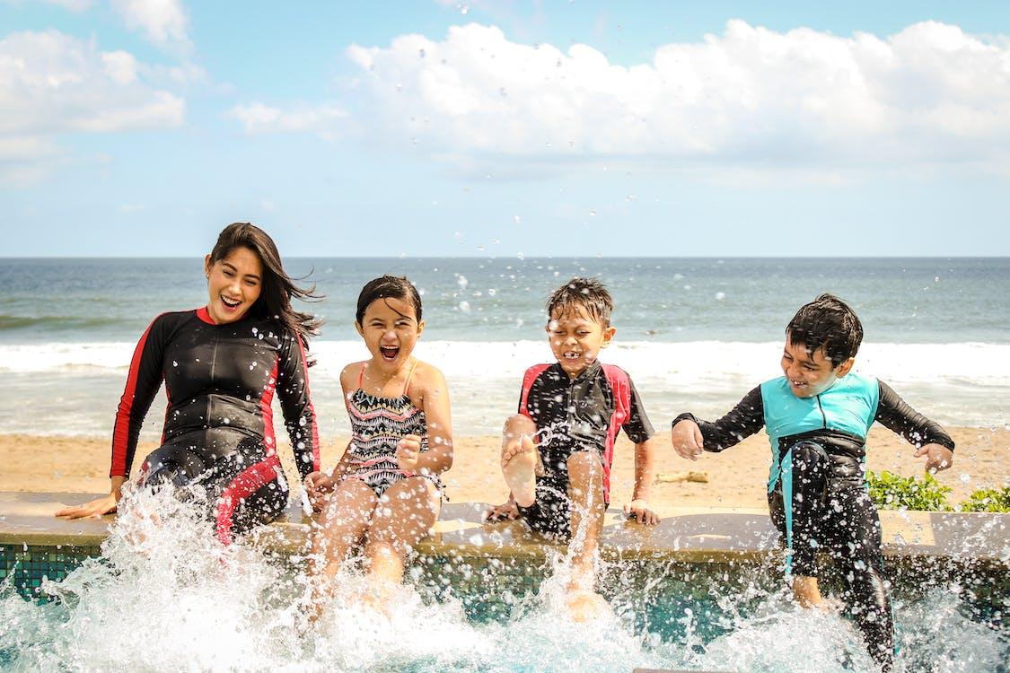 A family having fun splashing water near the seashore on a sunny day in Bali, Indonesia. 