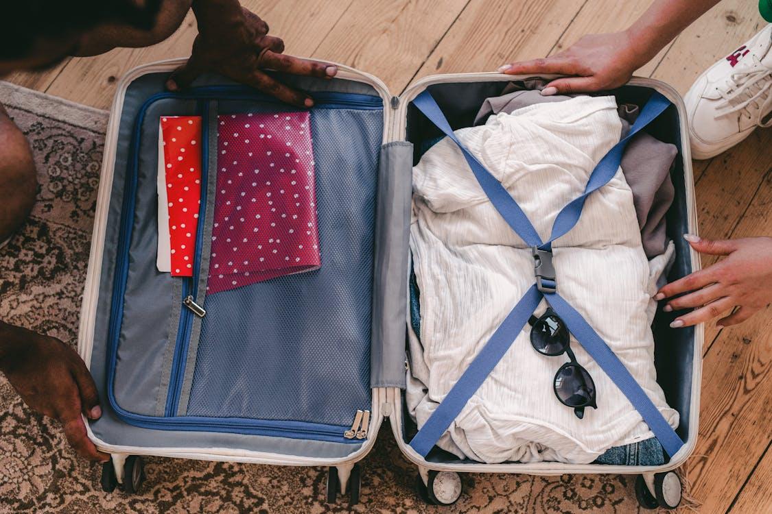 A neatly packed open suitcase with clothing and travel essentials, ready for a trip.