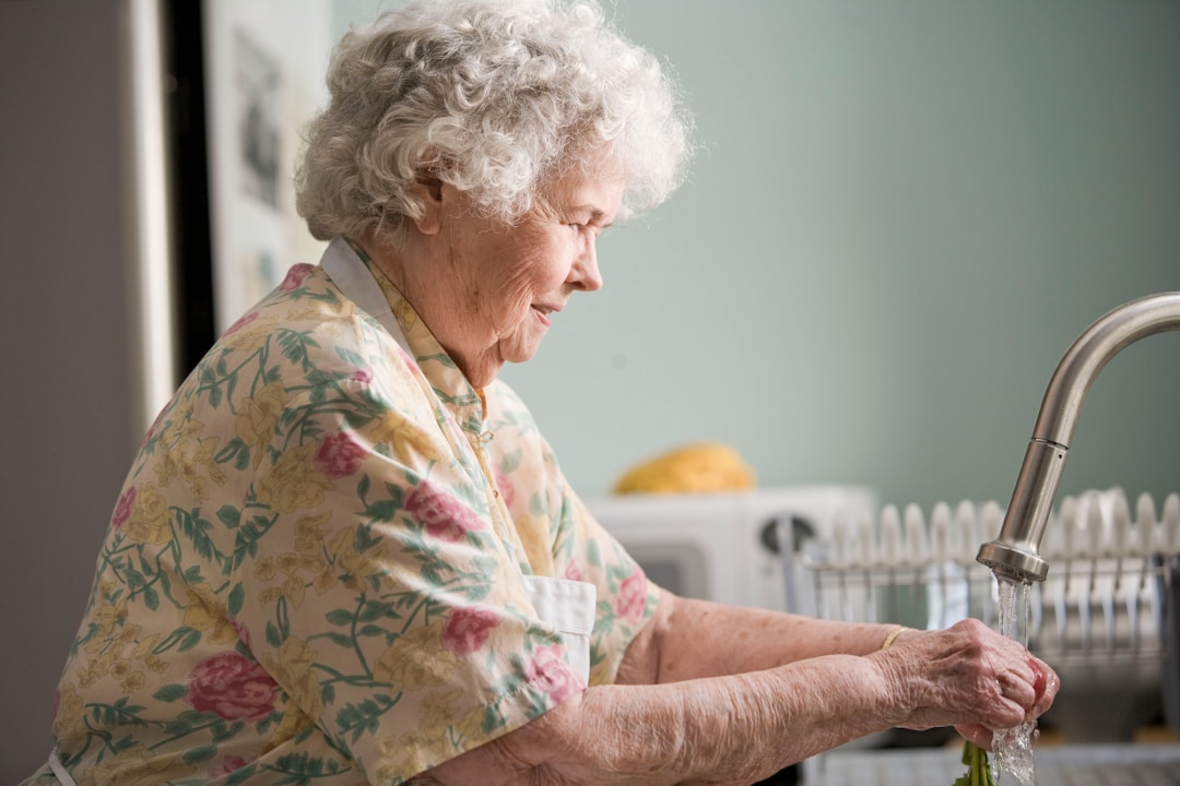 grandmother washing hands in the kitchen sink