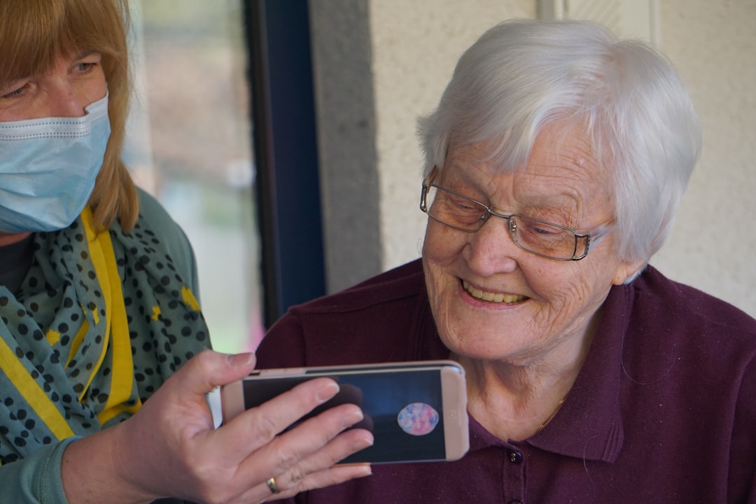 elderly woman looking at cellphone smiling